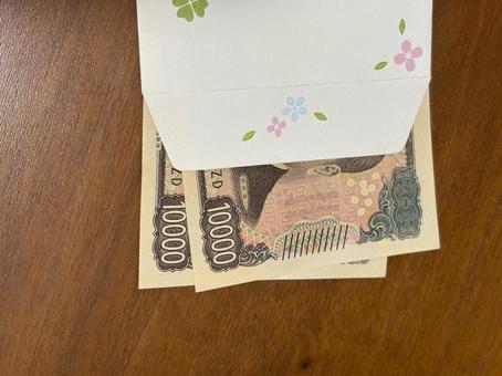 封筒にお金を入れる　２万円を入れる　謝礼 謝礼,一万円札,２万の写真素材