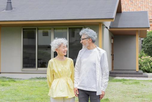 笑顔で住宅の前に立つシニア夫婦 笑顔で住宅の前に立つシニア夫婦 シニア,老人ホーム,マイホームの写真素材