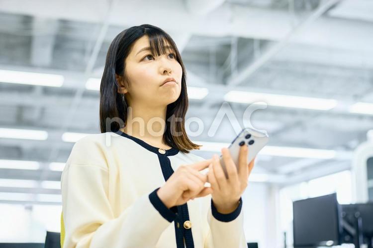 スマホ　困る　考える　若い女性　ビジネス スマホ,ビジネスウーマン,ビジネスシーンの写真素材