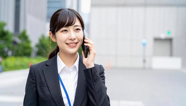 スマホで通話するビジネスウーマン スマホで通話するビジネスウーマンの写真