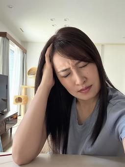 頭を抱える女性 頭を抱える女性 女性,30代,頭をかかえるの写真素材