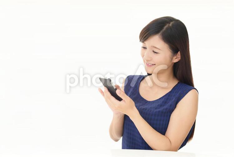 スマートフォンを持つ笑顔の女性 女性,スマートフォン,女の写真素材