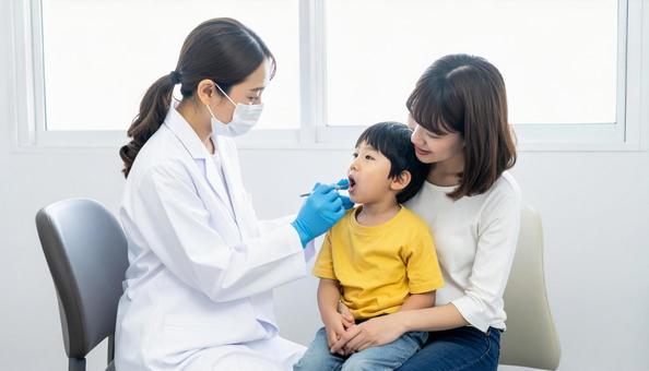 母に抱かれて歯医者さんから診察される子 母に抱かれて歯医者さんから診察される子の写真