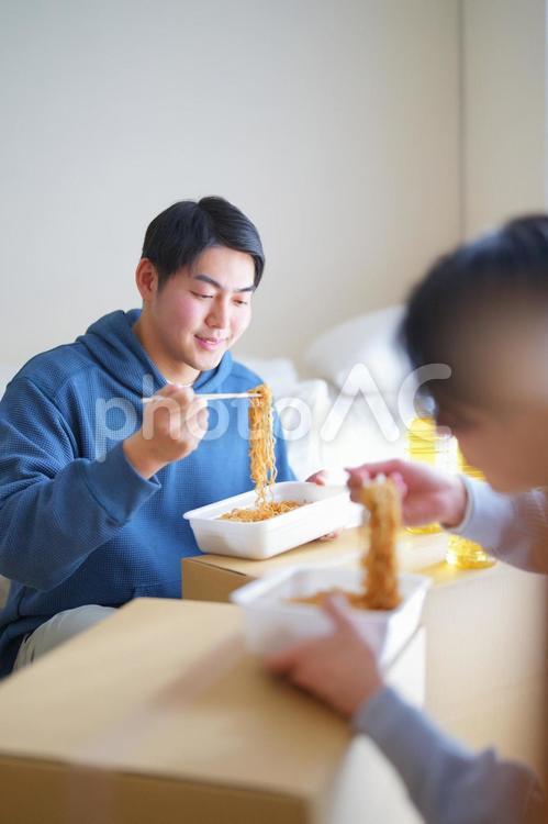 引っ越しの合間にカップ焼きそばを食べる2人の男性 引っ越し,一人暮らし,男性の写真素材