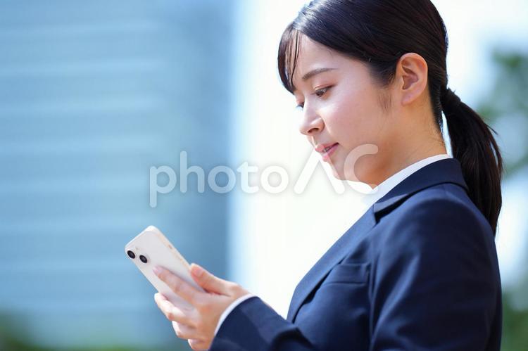 携帯を見ている女性の横顔 女性,人物,大学生の写真素材