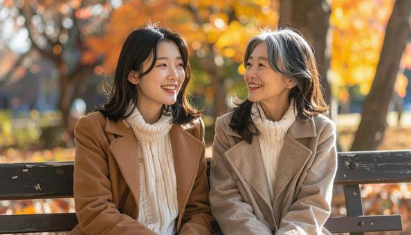 秋の公園の孫娘と祖母の写真