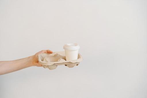 カップホルダーごと紙コップを差し出している手 配達,フードデリバリー,テイクアウトの写真素材