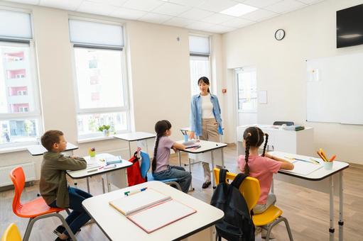 生徒たちに話す女性の先生 女性,女の子,男の子の写真素材