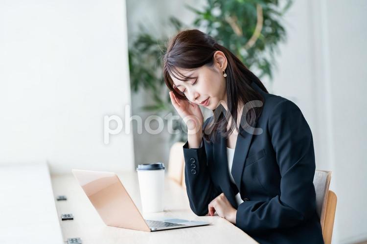 頭をおさえる女性 痛み,不調,働くの写真素材