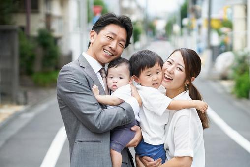 住宅街に立つ、笑顔の家族 住宅街に立つ、笑顔の家族 家族,育児,笑顔の写真素材