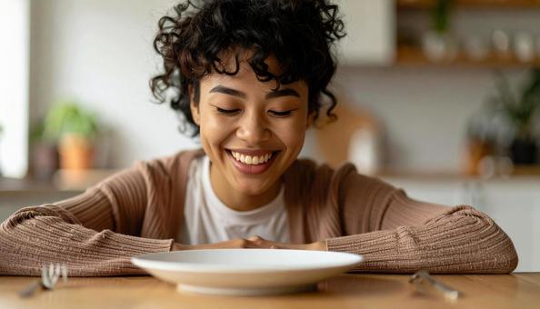 食後、空になったお皿を前に笑顔の女性 食後、空になったお皿を前に笑顔の女性の写真