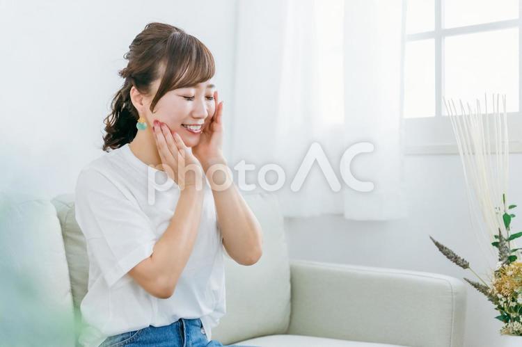 ソファでスキンケアのホームケアをする女性 スキンケア,美容,女性の写真素材