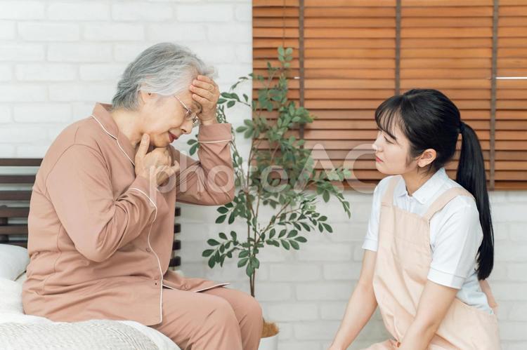 高齢者女性と介護する女性（悩む・頭痛） 頭痛,介護士,高齢者の写真素材