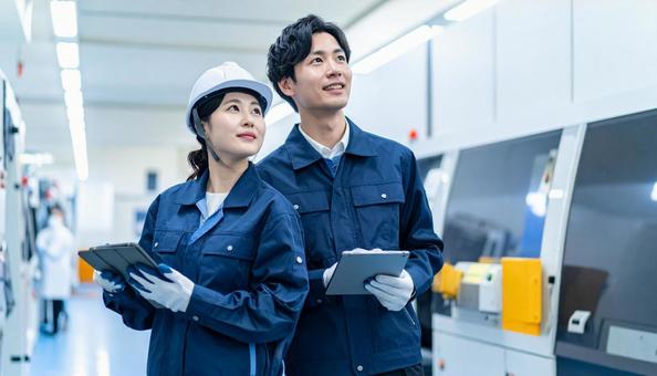 工場でタブレットで製品を検査する作業員 工場でタブレットで製品を検査する作業員の写真