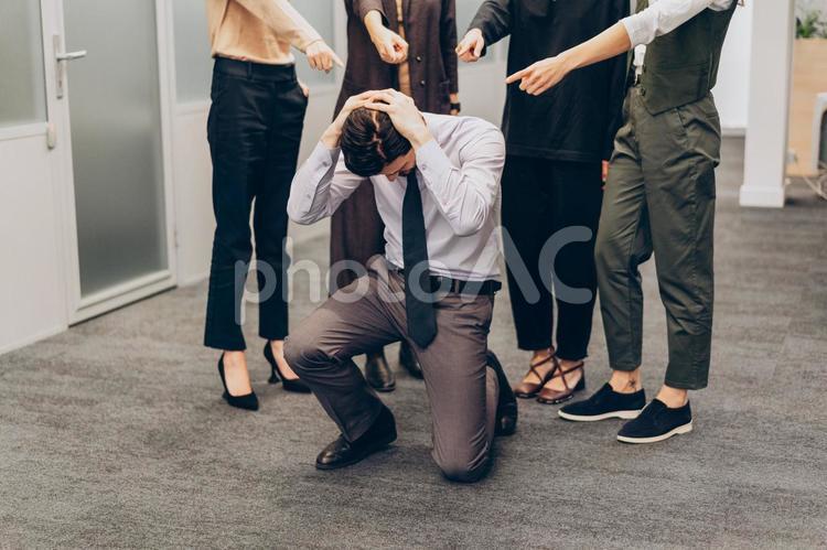 オフィスでみんなに指をさして責められている男性 コワーキング,ビジネス,女性の写真素材