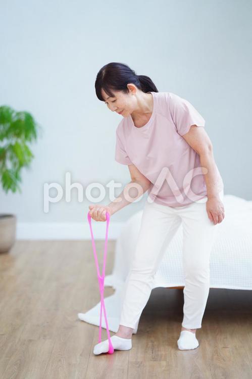 ゴムチューブで腕のトレーニングをする中年女性 主婦,シニア,立ち姿の写真素材