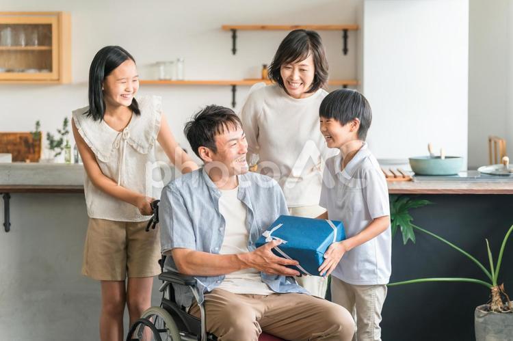 車椅子の家族を支える家族・退院した父親 退院,父親,父の日の写真素材