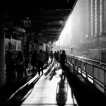 夕暮れに長い影を落とす都市の歩行者の写真