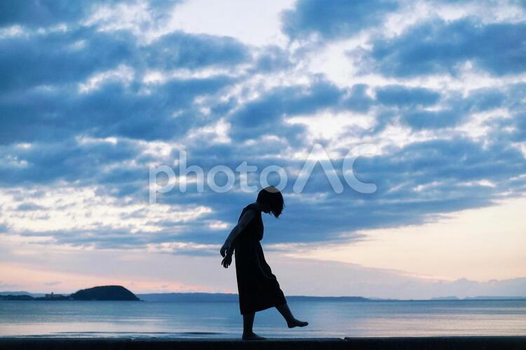 夕日と女の子のシルエット 暗い,青,夕陽の写真素材