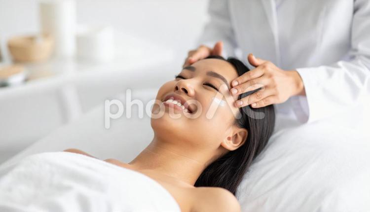 美容皮膚科で女性にクリームを塗る看護師 美容皮膚科,相談,アンチ・エイジングの写真素材