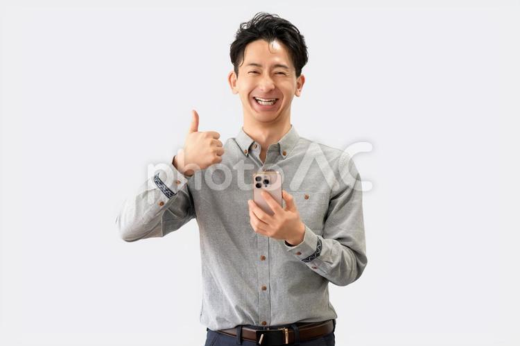 スマホを持っていいね！のポーズをする男性 男性,スマホ,笑顔の写真素材