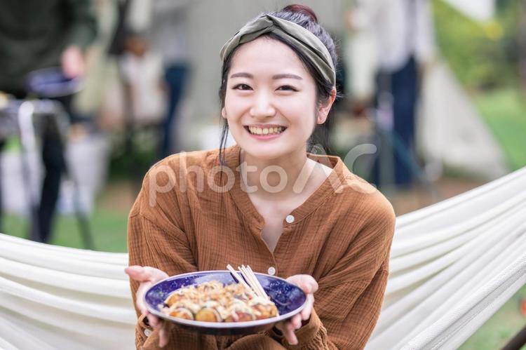 キャンプでたこ焼きを食べる女性 キャンプ,食べる,女性の写真素材