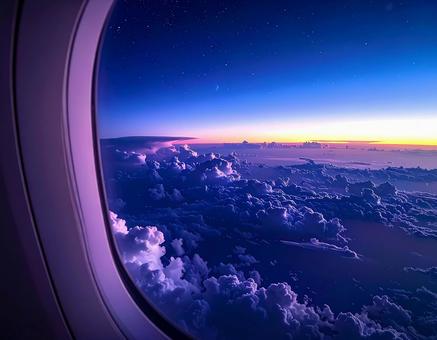 機内の窓から見える夕暮れの雲海 機内の窓から見える夕暮れの雲海の写真