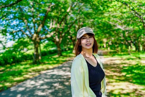晴れた日に公園を歩く女性 晴れた日に公園を歩く女性 散歩,ダイエット,ウォーキングの写真素材