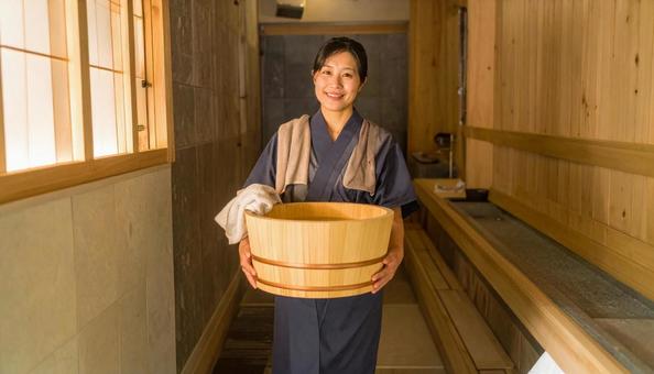 温泉を木桶を持って歩く仲居の日本人女性 温泉を木桶を持って歩く仲居の日本人女性の写真