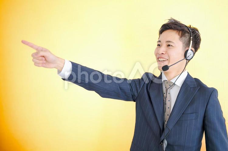 指差すビジネスマン ヘッドセット,案内,サポートの写真素材