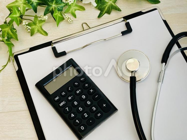医療費・高額療養費・診療報酬 聴診器,電卓,クリップボードの写真素材