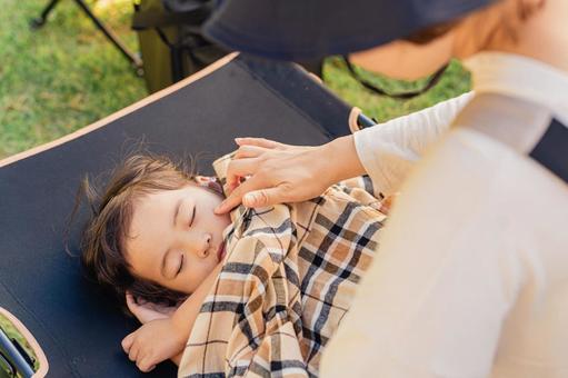 キャンプ場で遊び疲れてコットに眠る子供 昼寝,体調不良,急病の写真素材