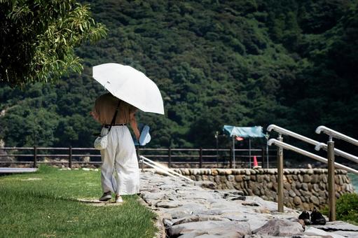 <素材>秋の海を散策する女性の後ろ姿 <素材>秋の海を散策する女性の後ろ姿の写真