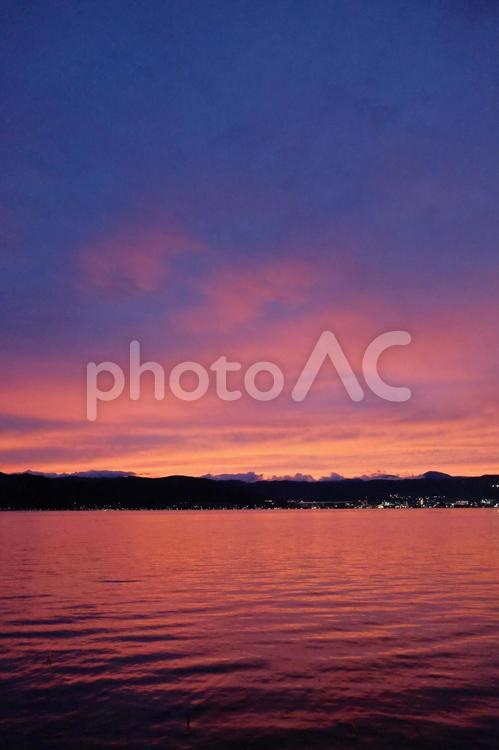 湖面が赤く反射した夕焼けの諏訪 冬,夕暮れ,夕焼けの写真素材