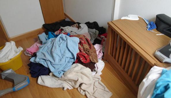 洗濯ものが散乱している女性の狭い部屋 洗濯ものが散乱している女性の狭い部屋の写真