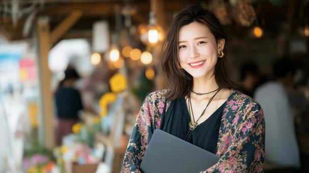 カフェでノートパソコンを抱える女性の写真