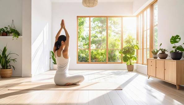自然光が入る部屋でヨガをする女性の後ろ姿の写真