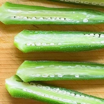 木のまな板に並べたオクラの断面 木のまな板に並べたオクラの断面の写真