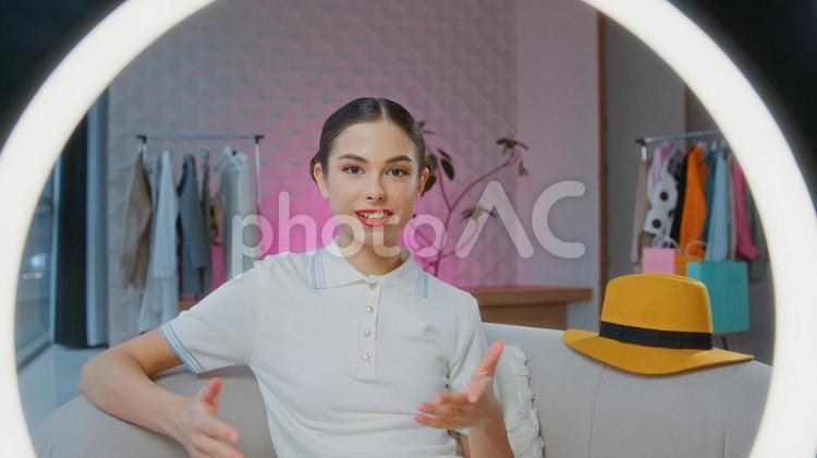 カメラ目線でで肘をついて話す女性とリングライト 女性,人物,インフルエンサーの写真素材