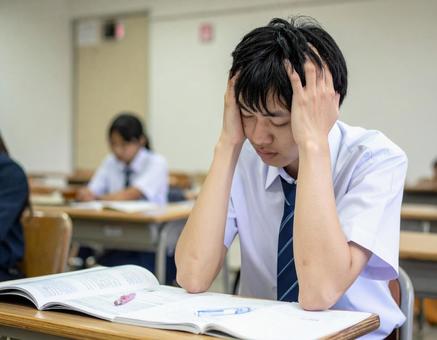 難しい問題に頭を抱える生徒・学生 難しい問題に頭を抱える生徒・学生の写真