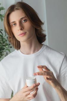クリームを塗るカメラ目線の男性の写真