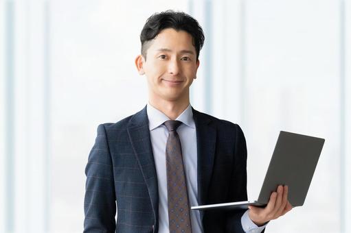 ノートパソコンを持つ男性ビジネスマン ノートパソコンを持つ男性ビジネスマン 男性,パソコン,ノートパソコンの写真素材