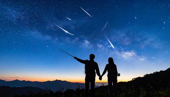 流星群を見る人のシルエット 流星群を見る人のシルエットの写真