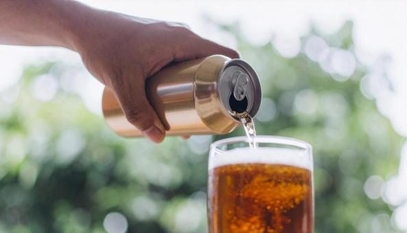 缶ビールからグラスにビールを注ぐ手 缶ビールからグラスにビールを注ぐ手の写真