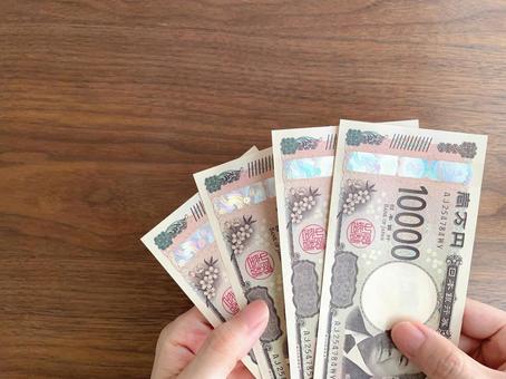 机上で4万円を持つ女性の手 机上で4万円を持つ女性の手 お金,給付金,手の写真素材
