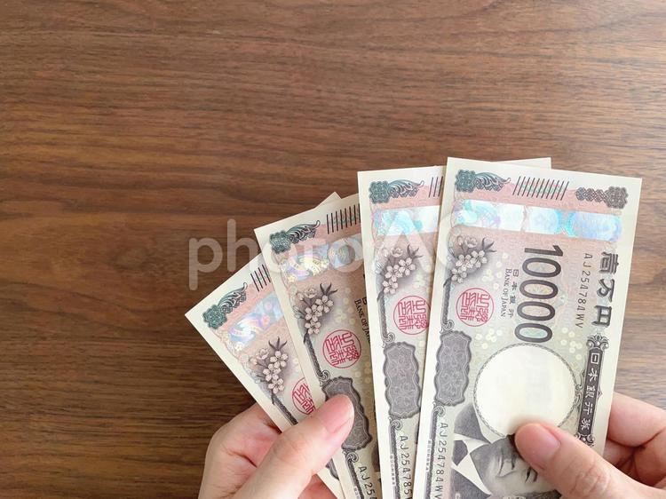 机上で4万円を持つ女性の手 お金,給付金,手の写真素材