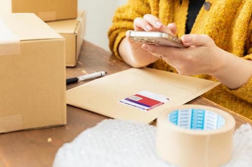 荷物の発送準備をする女性 配送,配達,段ボールの写真素材