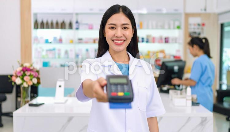 カードリーダーを差し出す制服姿のスタッフ 店舗業務,接客,サービス業の写真素材