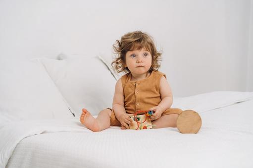 玩具を触りながらお座りする子 赤ちゃん,かわいい,玩具の写真素材