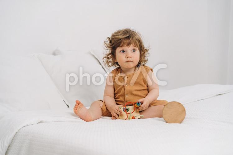 玩具を触りながらお座りする子 赤ちゃん,かわいい,玩具の写真素材